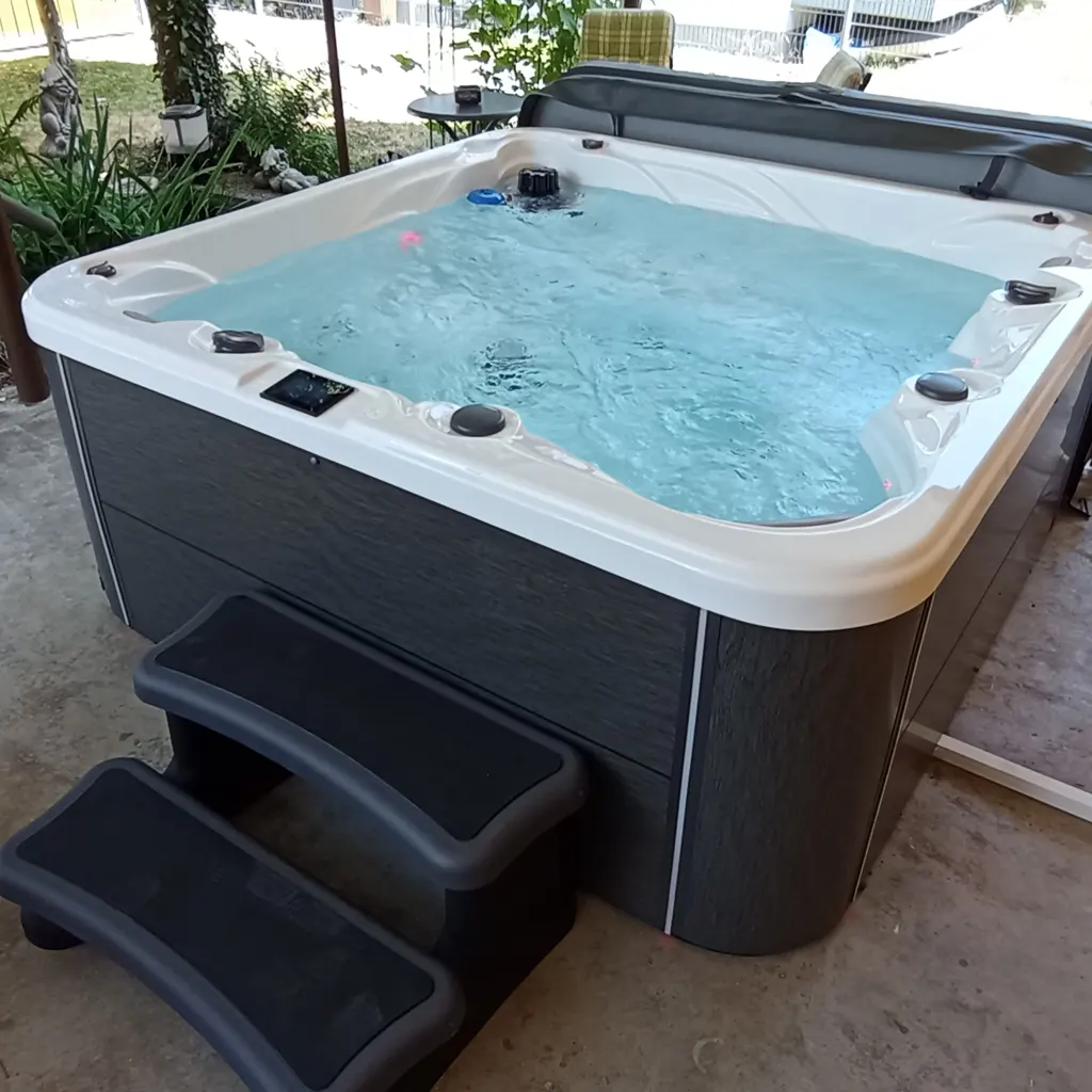 Outdoor Whirlpool mit Wasser und Einstiegstreppe